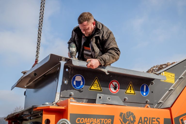 Arbeiter montiert Trichterwände am ARJES COMPAKTOR 300