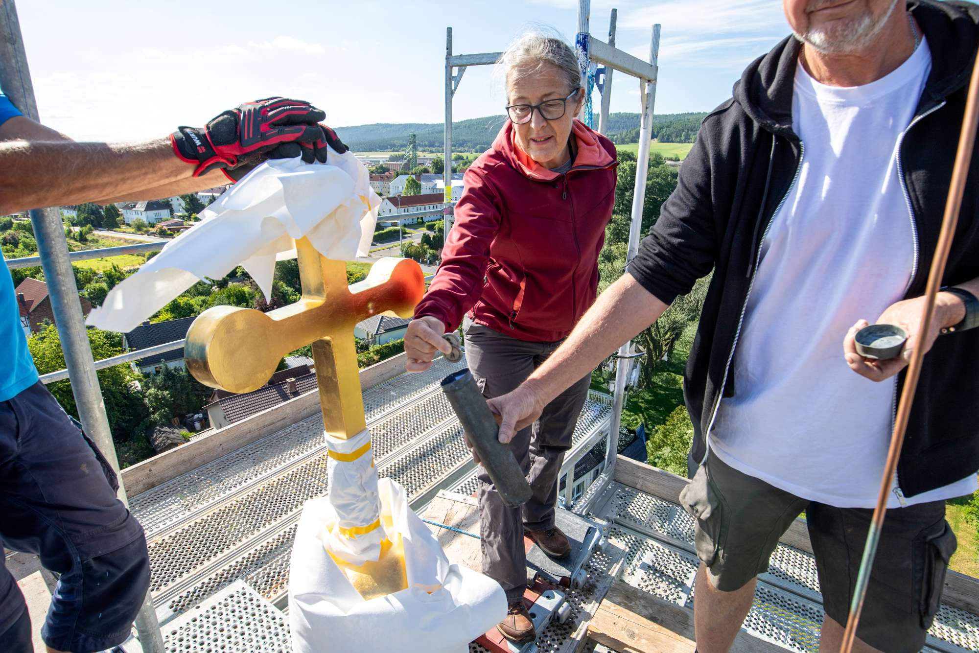Ein besonderer Moment: Die Zeitkapsel mit Erinnerungsstücken wird feierlich in die Turmkugel eingesetzt.