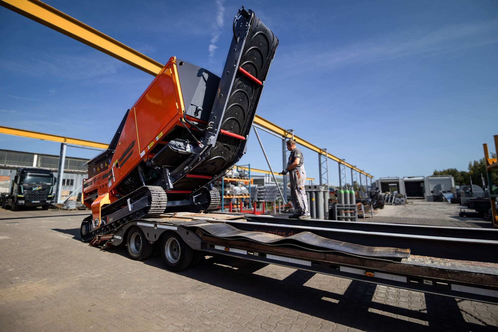 The EKOMAXX 800 mobile two-shaft shredder being loaded onto a low-loader trailer